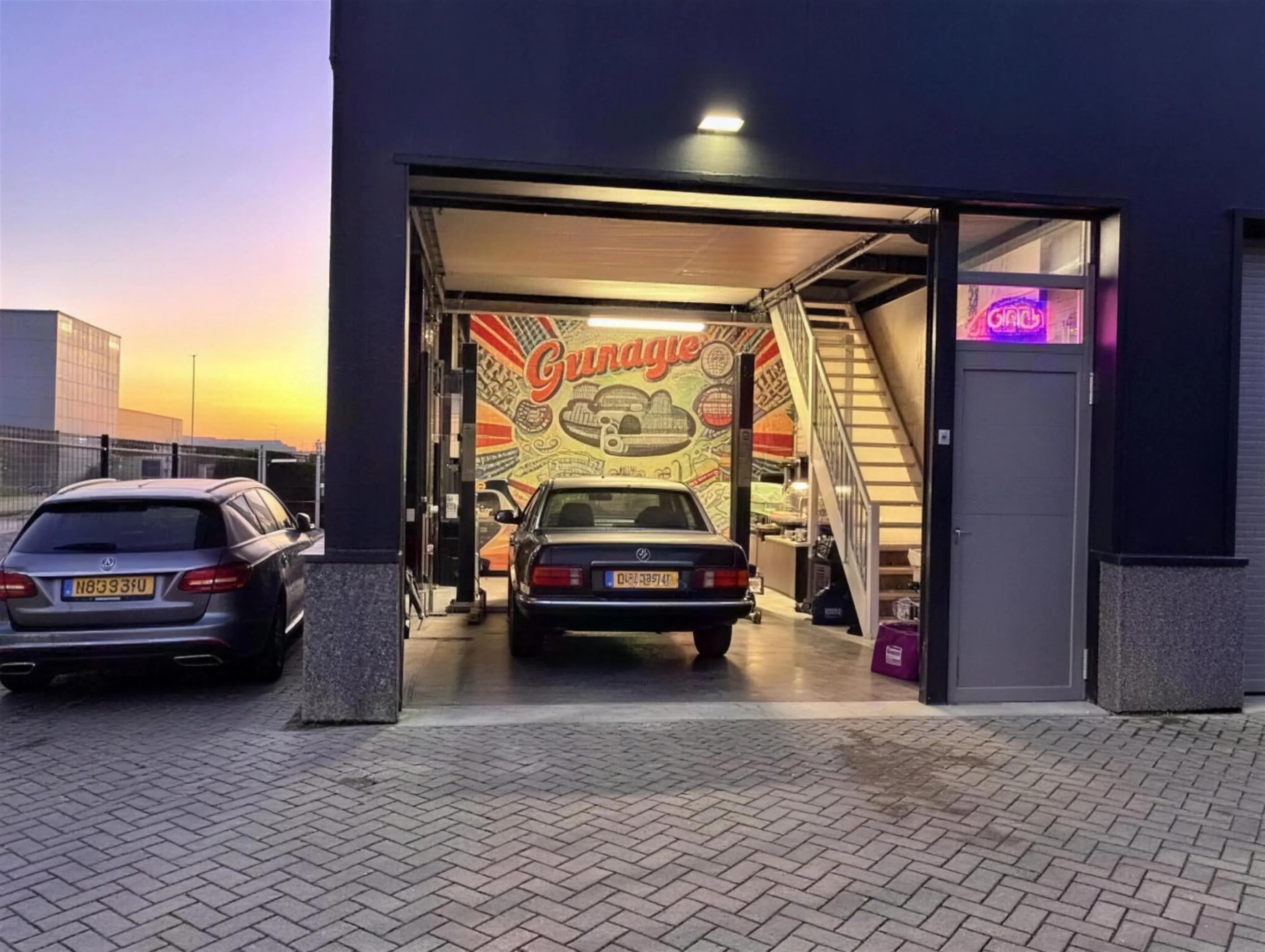 Motordiagnose: monteur leest een auto met open motorkap uit met een diagnosetablet in een werkplaats